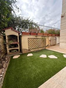 a backyard with a garden with a fireplace and green grass at LUX APARTMENT CAPANNELLE in Rome