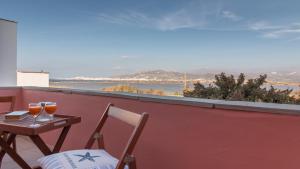 una mesa y sillas en un balcón con vistas al océano en Blue Heart Luxury Suites II, en Naxos Chora