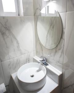 Baño blanco con lavabo y espejo en Hotel Atenas, en Xalapa