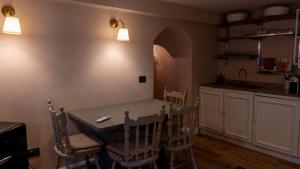 a kitchen with a table and chairs in a room at Bilocale a due passi dal mare immerso nel verde in Castiglioncello