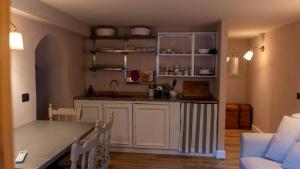 a kitchen with white cabinets and a table in a room at Bilocale a due passi dal mare immerso nel verde in Castiglioncello