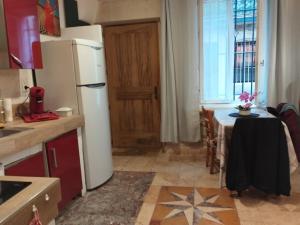 a kitchen with a white refrigerator and a table at Très bel appartement cosy et chaleureux à Nîmes in Nîmes