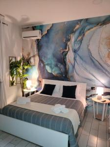 ナポリにあるB&B Anema&Coreのベッドルーム1室(壁に絵画が描かれたベッド1台付)