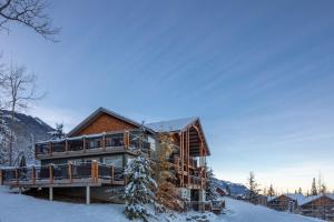 uma cabana de madeira na neve com neve coberta em Lush Mountain Accommodations em Golden
