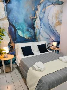 ナポリにあるB&B Anema&Coreの壁に絵画が飾られた部屋のベッド2台