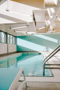 an indoor swimming pool with blue water in a building at Blue Horizon Hotel in Vancouver