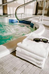 une paire de lunettes de soleil assise sur une serviette à côté d'une baignoire dans l'établissement Blue Horizon Hotel, à Vancouver