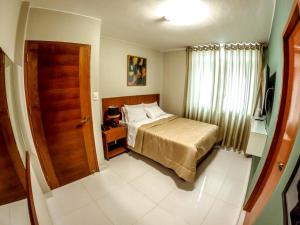 una piccola camera con un letto e una porta di Hotel Cisneros 700 a Lima