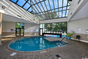 a large swimming pool in a building with a glass ceiling at Family friendly, cozy, home at the beach in Myrtle Beach