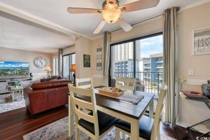 a living room with a dining room table with a ceiling fan at Family friendly, cozy, home at the beach in Myrtle Beach