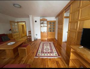 a living room with wooden floors and wooden doors at Villa Aleksandra Jahorina in Jahorina