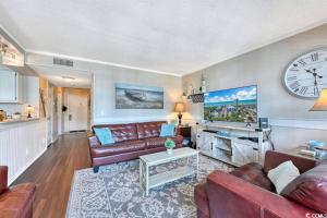 a living room with a couch and a clock on the wall at Family friendly, cozy, home at the beach in Myrtle Beach