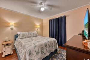 a bedroom with a bed and a flat screen tv at Family friendly, cozy, home at the beach in Myrtle Beach +21 photos