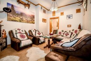 a living room with leather furniture and a table at Domek u Zosi in Zakopane