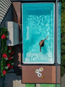 a person swimming in a swimming pool in a swimming pool at Athesense Suites in Athens
