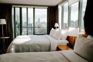 a hotel room with two beds and a large window at Blue Horizon Hotel in Vancouver