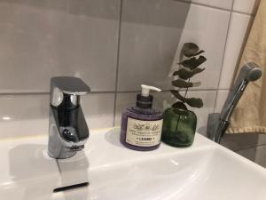 a bathroom sink with a bottle of soap and a coffee maker at Brand New and Cozy Modern Studio! WithAirCondition in Turku