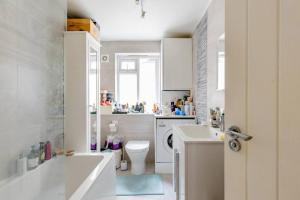 uma casa de banho branca com um WC e um lavatório em A lovely and comfortable flat in South London em Thornton Heath
