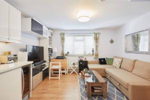 uma sala de estar com um sofá e uma mesa em A lovely and comfortable flat in South London em Thornton Heath