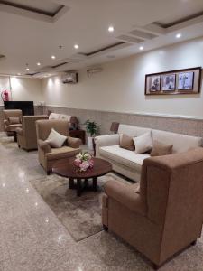una sala d'attesa con divani e tavolino di داركم 2 للشقق المخدومة a Buraydah