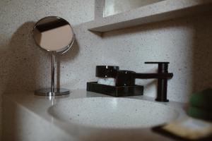 a bathroom sink with a mirror and a faucet at Otro Oaxaca, a Member of Design Hotels in Oaxaca City