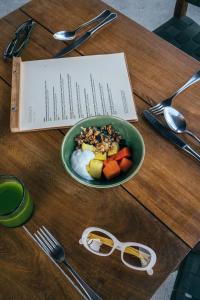 una mesa de madera con un plato de comida y un plato de fruta en Terrestre, a Member of Design Hotels en Puerto Escondido