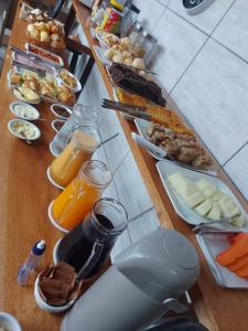 a long table with breakfast foods and orange juice at Hospedagem Quinta do Correia in Penha