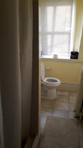 a bathroom with a toilet and a window at Pleasant Rooming House in Washington