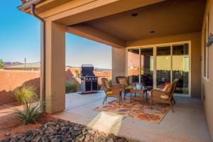 a patio with a table and chairs and a grill at 5-7 | 3 Homes in St. George with Covered Patio Views in Santa Clara