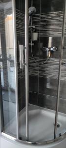 a shower with a glass door in a bathroom at Apartament Hokus Pokus in Bardo