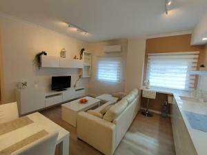 sala de estar con sofá blanco y TV en Non Stress Turia en Valencia