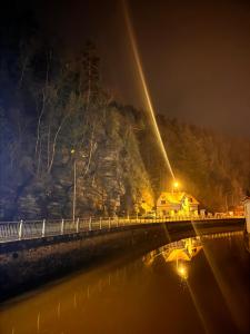 a train station at night with a reflection in the water at Hřensko 27 Apartmány in Hřensko