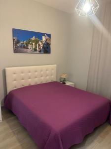 een slaapkamer met een bed met een paarse sprei bij La casa di Angy in Acquaviva delle Fonti