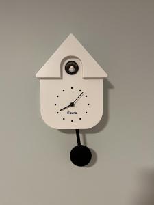 a white bird clock on a white wall at Coucou - Nest im Schwarzwald in Gengenbach