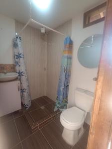 a bathroom with a toilet and a shower curtain at Hotel Rancho El Vergel in Montenegro