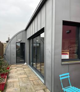 una silla azul sentada en un patio junto a un edificio en Magnifique loft 130m2 Le Mans, en Le Mans