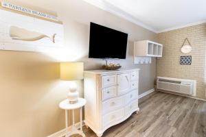 a room with a white dresser with a television on it at Charming Oceanview King Efficiency on the 2nd Flr in Pawleys Island