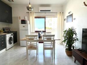 kuchnia ze stołem i krzesłami w pokoju w obiekcie CASA COSY - Caparica Beach and Surf Apartment w Costa de Caparica