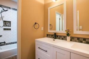 a bathroom with a sink and a mirror and a tub at Remodeled Large home w yard Gated PRIME location in Albuquerque