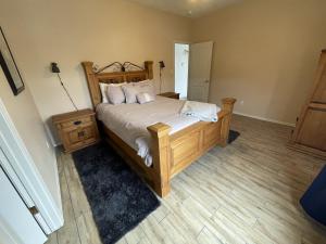 a bedroom with a large bed with a wooden headboard at Remodeled Large home w yard Gated PRIME location in Albuquerque