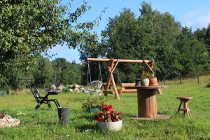 a swing in a yard with flowers in a field at OSTOJA PAWIE OKO in Potęgowo