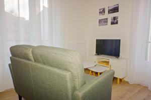 uma sala de estar com uma cadeira e uma televisão em Studio Bacivers em Prats-de-Mollo-la-Preste