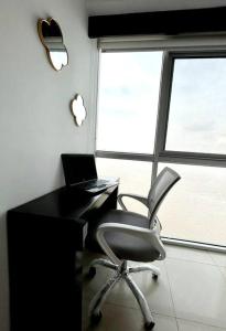 a office with a chair and a desk with a laptop at Ecusuites vista Río Jacuzzi Privado Wyndham 802 in Guayaquil