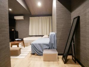 1 Schlafzimmer mit 2 Betten, einem Tisch und einem Fenster in der Unterkunft HOOD - Vacation STAY 46032v in Amami
