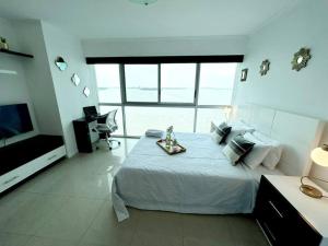 a bedroom with a large bed and a large window at Ecusuites vista Río Jacuzzi Privado Wyndham 802 in Guayaquil