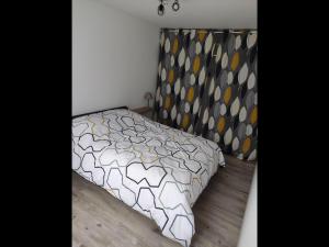 1 dormitorio con cama con colcha estampada en Maison calme et chaleureuse, en Léré