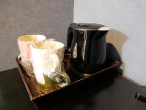 czarny dzbanek do kawy siedzący na stole w obiekcie HOOD - Vacation STAY 46460v w mieście Amami