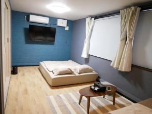 a bedroom with a bed and a table in it at HOOD - Vacation STAY 46038v in Amami