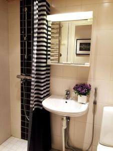 a bathroom with a sink and a mirror and a shower at Turku Central Nordic Stylish Cozy flat 50m2 in Turku