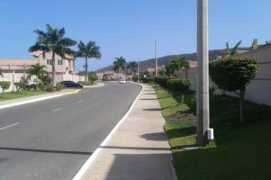 une rue vide avec un poteau sur le côté de la route dans l'établissement Comfortable Strategic Lodging Quarters, à Spanish Town